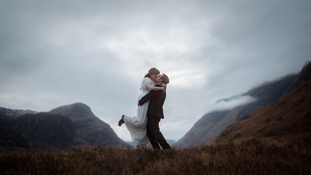 Couple eloping in Scotland with mountains behind them